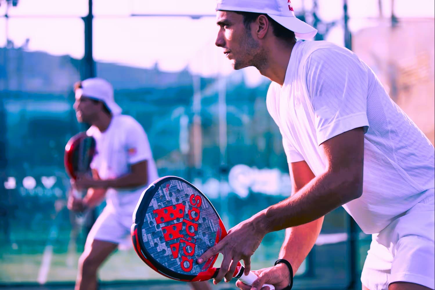 Two padel players holding rackets and preparing for play
